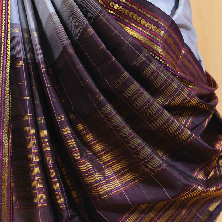 Close-up of a purple and gold saree with intricate patterns