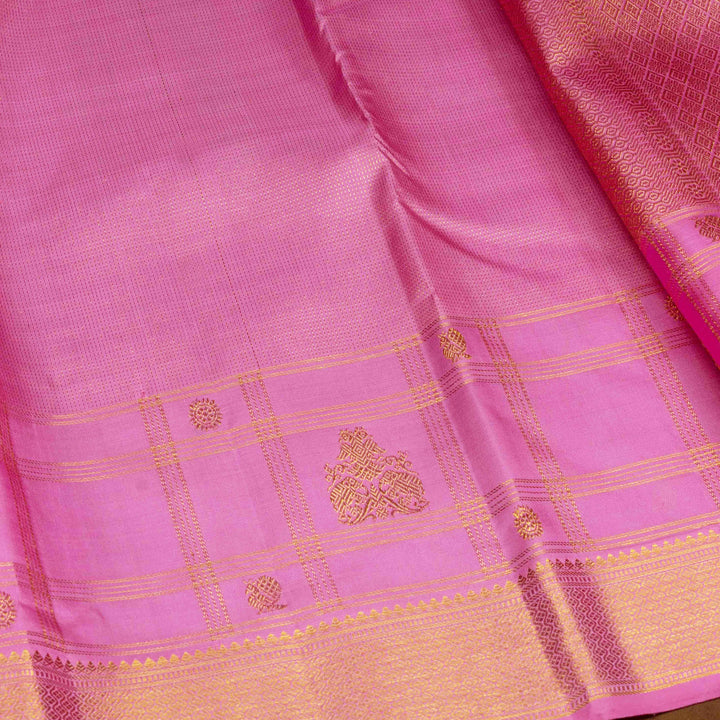 Close-up of a pink saree with gold border and patterns