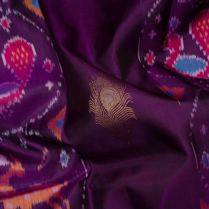 Close-up of purple fabric with intricate patterns and a gold embroidered design.