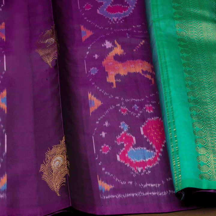 Close-up of a purple fabric with intricate patterns and a green border.