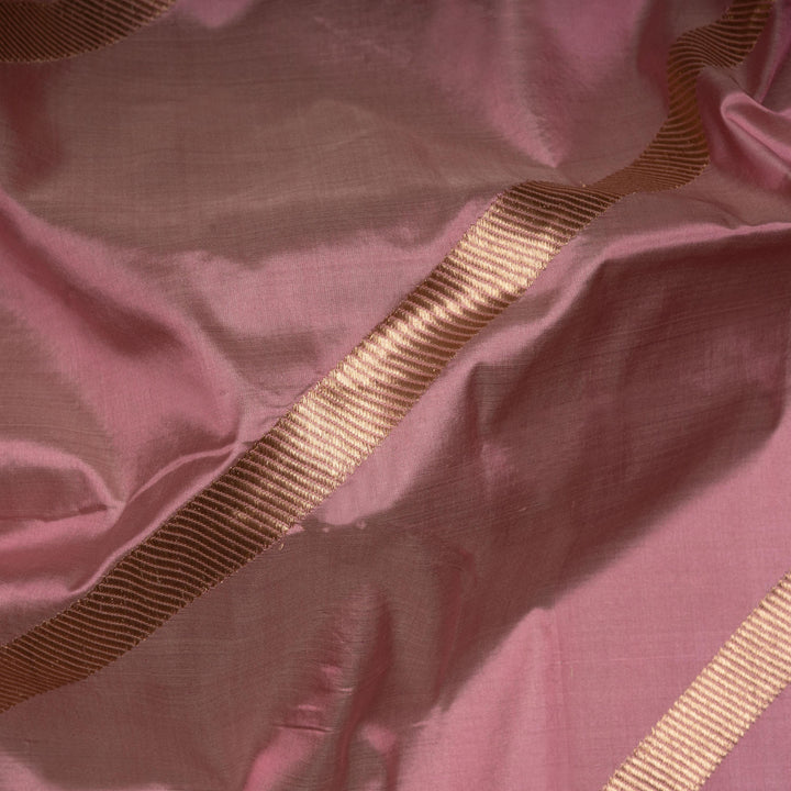 Close-up of pink fabric with a gold ribbon