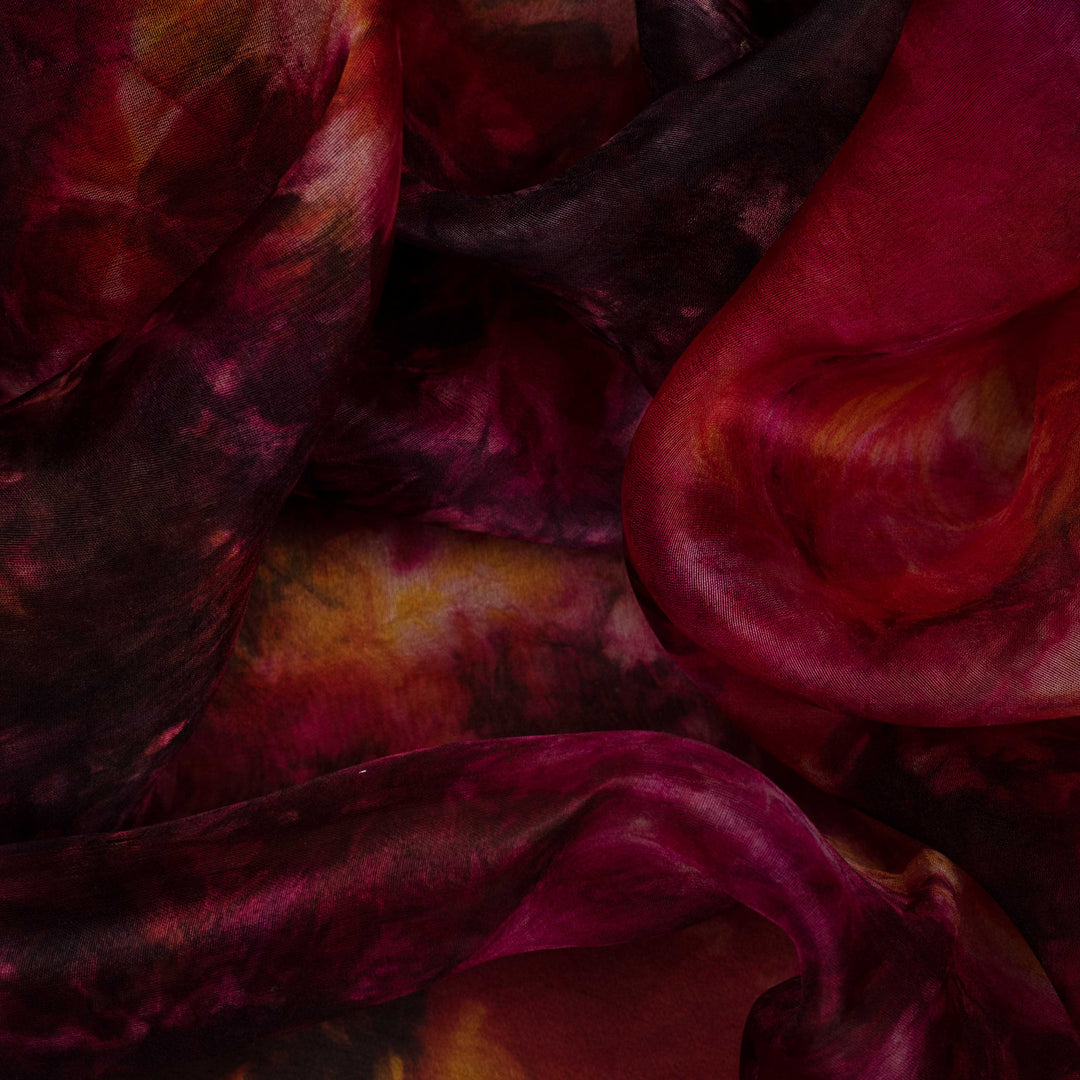 Closeup view of Handwoven maroon organza silk saree with abstract multicolour patterns.