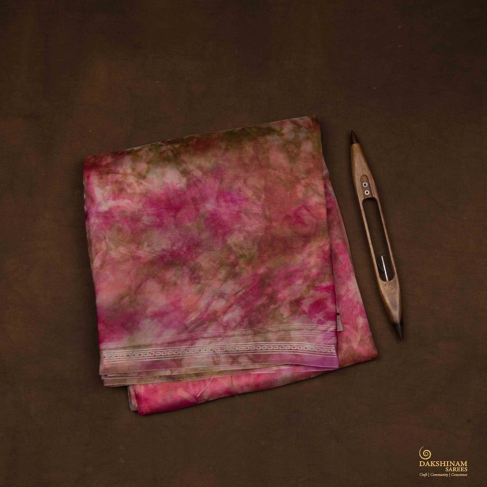 Closeup view of Handwoven pink organza silk saree with multicolour abstract patterns and silver zari accents.