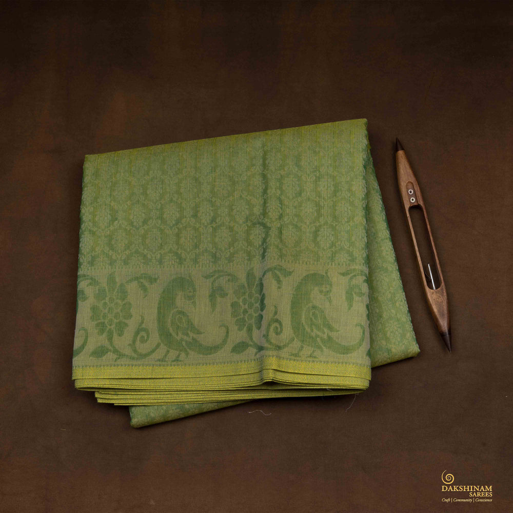 Closeup view of a Handwoven green South cotton saree with parrots, floral vines, paisleys.