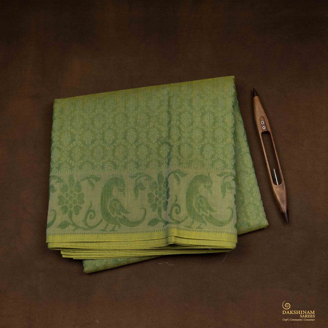 Closeup view of a Handwoven green South cotton saree with parrots, floral vines, paisleys.