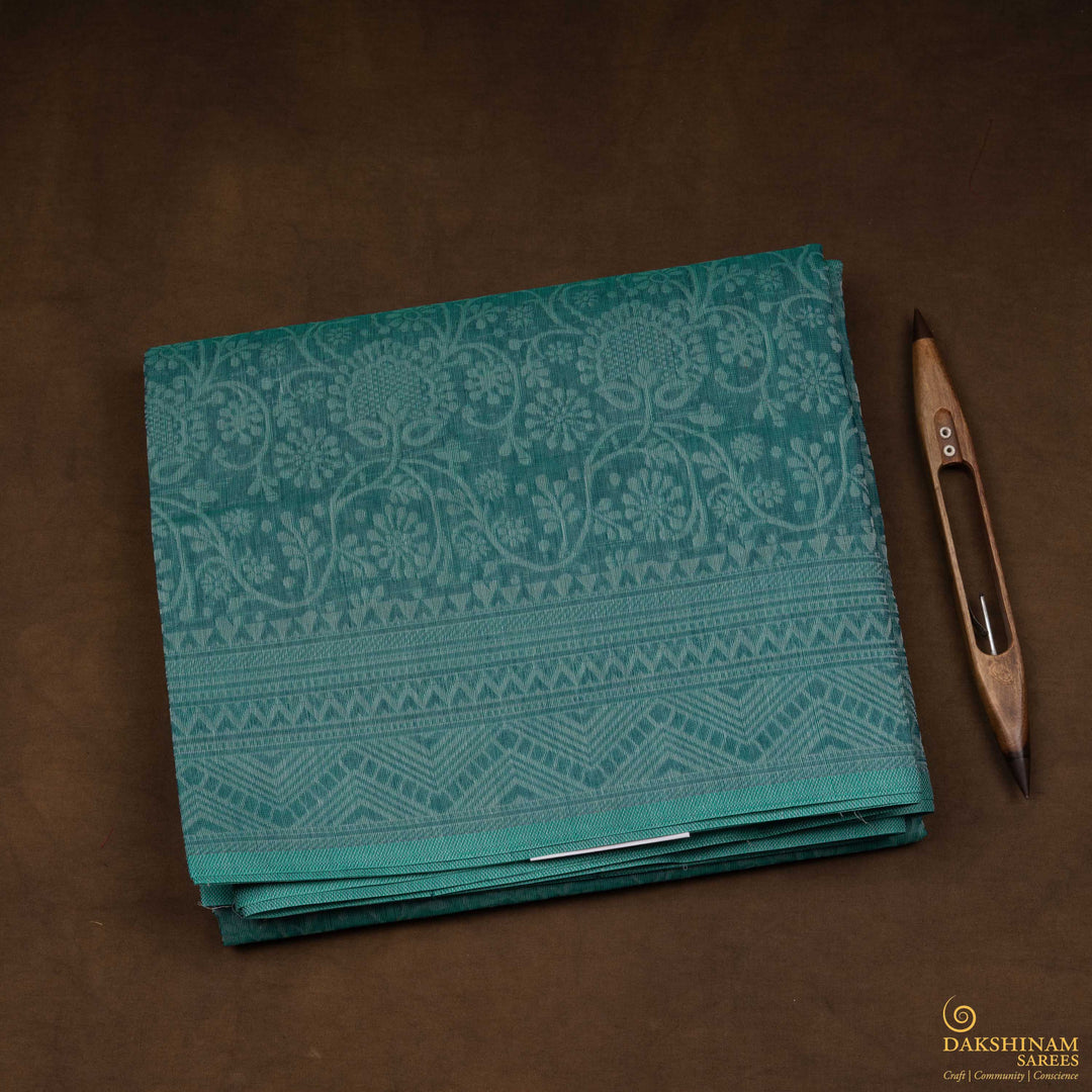 Closeup view of a Authentic teal South cotton saree with floral vines.