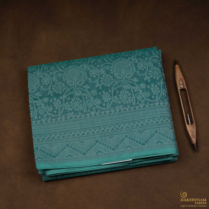 Closeup view of a Authentic teal South cotton saree with floral vines.