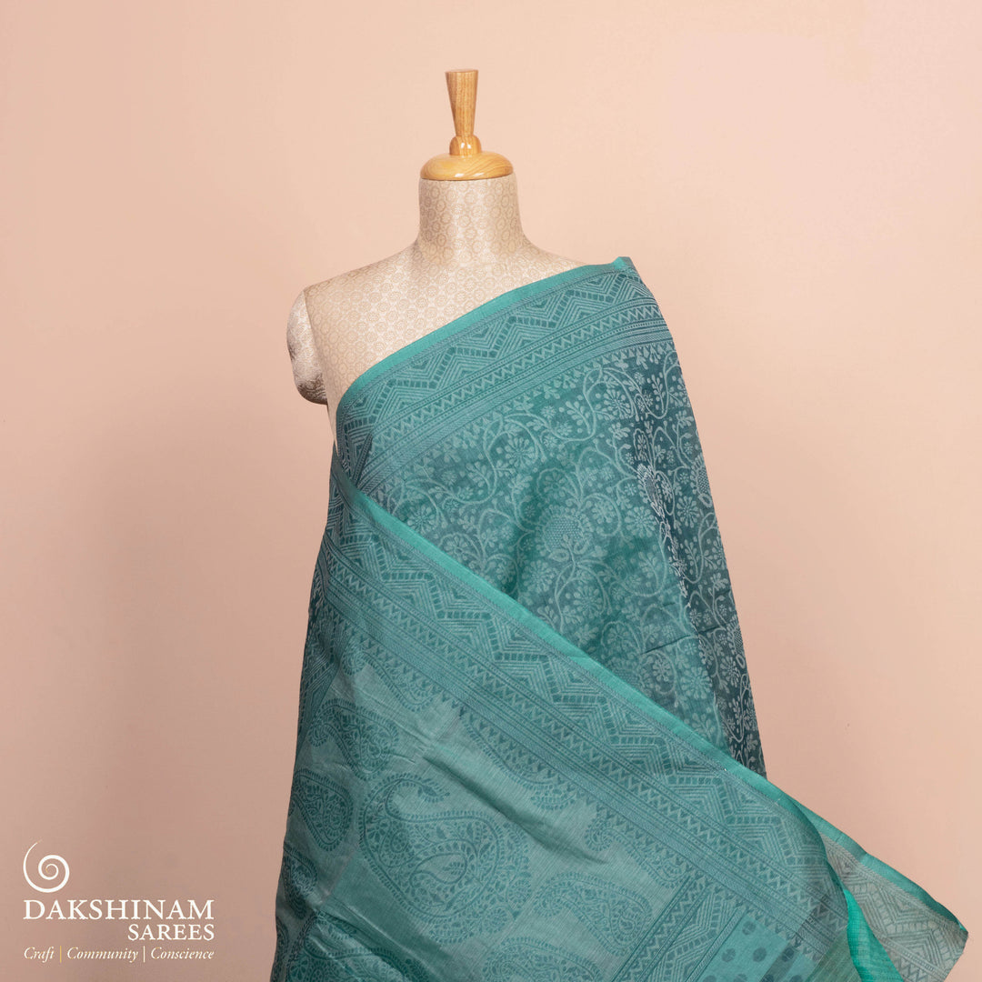 Full body view of a Authentic teal South cotton saree with floral vines.