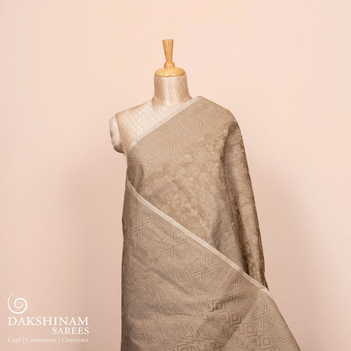 Full view of a Authentic beige South cotton saree with hut-shaped motifs.