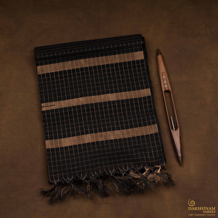Closeup view of a Lightweight moss brown silk cotton saree with black gold zari border, checks, paisleys, temple and chevron motifs.