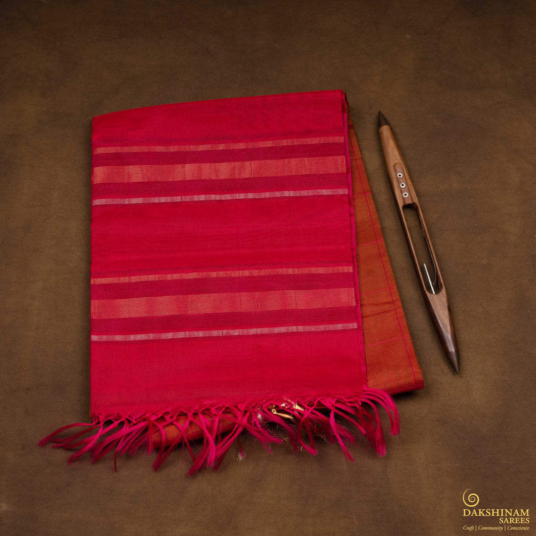 Closeup view of a Lightweight rust orange silk cotton saree with pink gold-silver zari border.