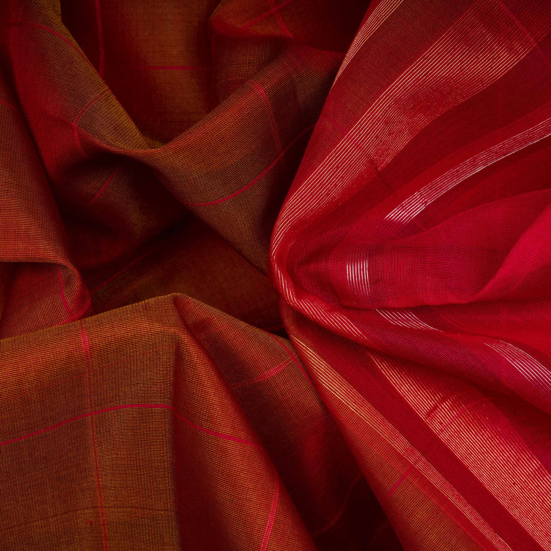Closeup of a Lightweight rust orange silk cotton saree with pink gold-silver zari border.