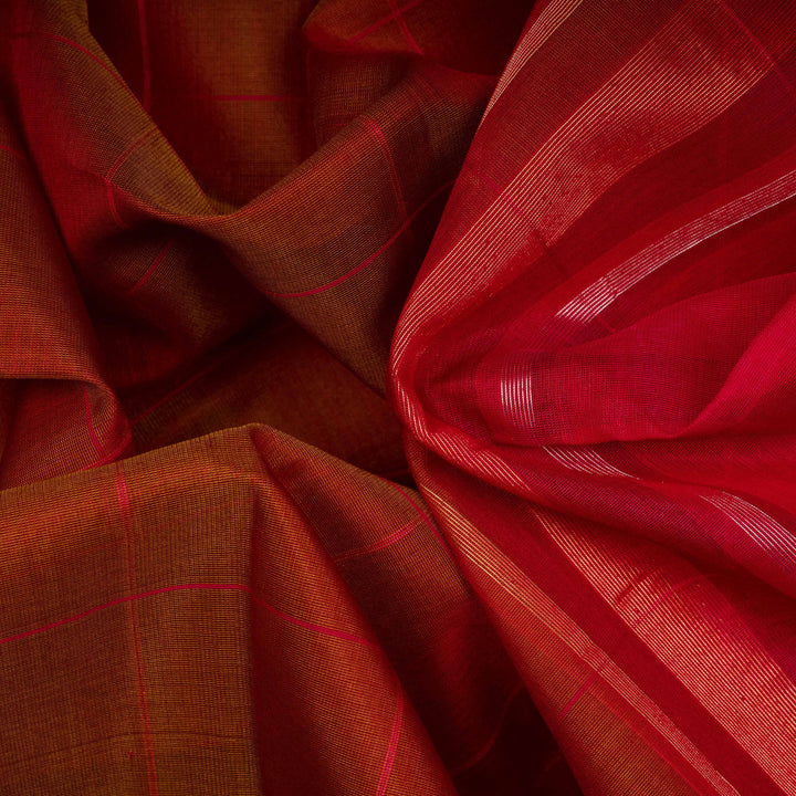 Closeup of a Lightweight rust orange silk cotton saree with pink gold-silver zari border.