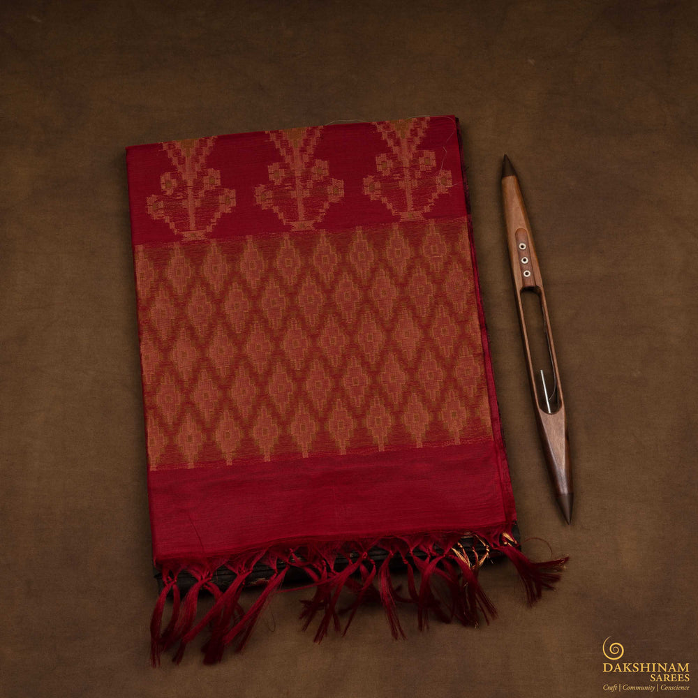 Closeup view of a Lightweight grey silk cotton saree with maroon meenakari floral border.
