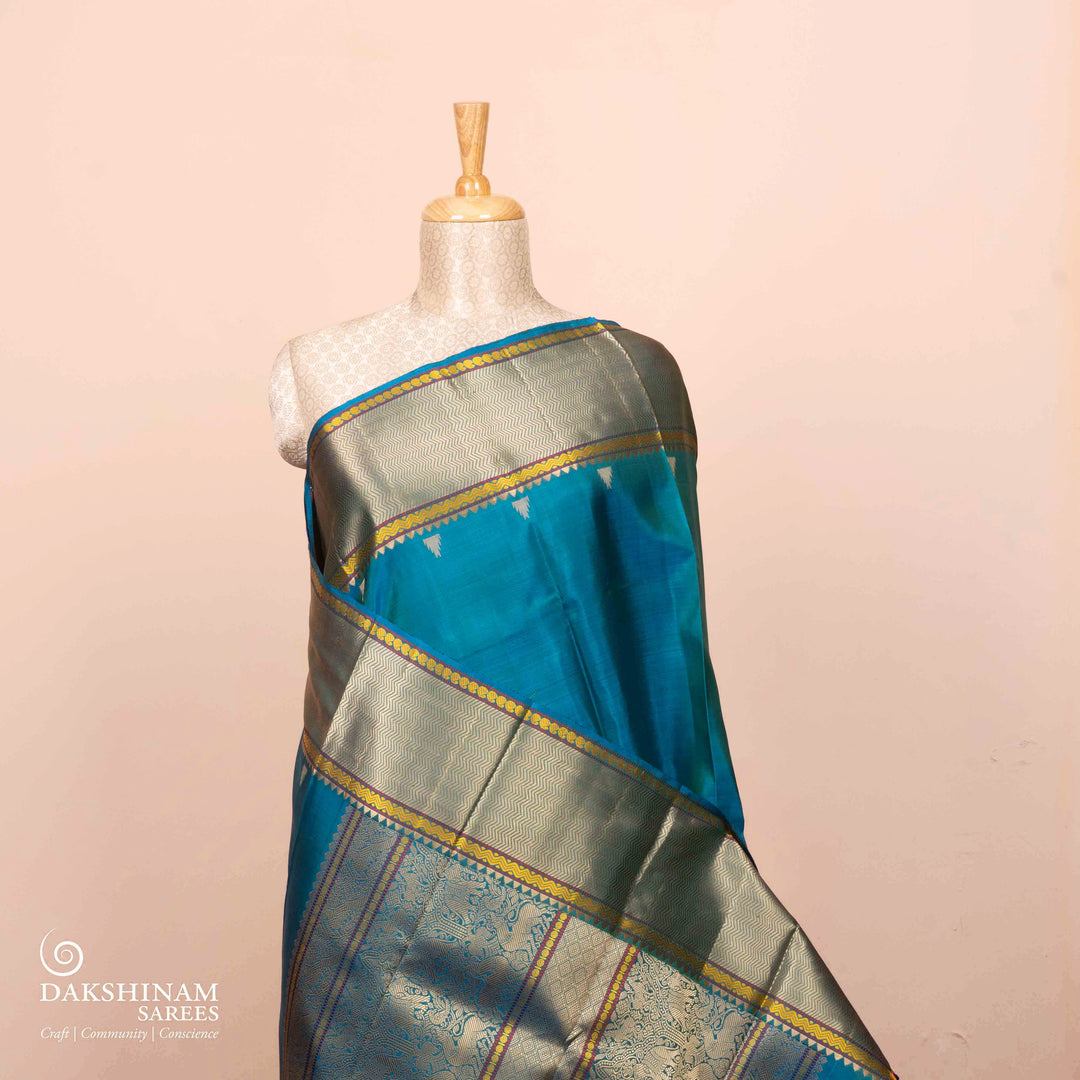 Full view of a Blue plain Kanjivaram silk saree with threadwork motifs.