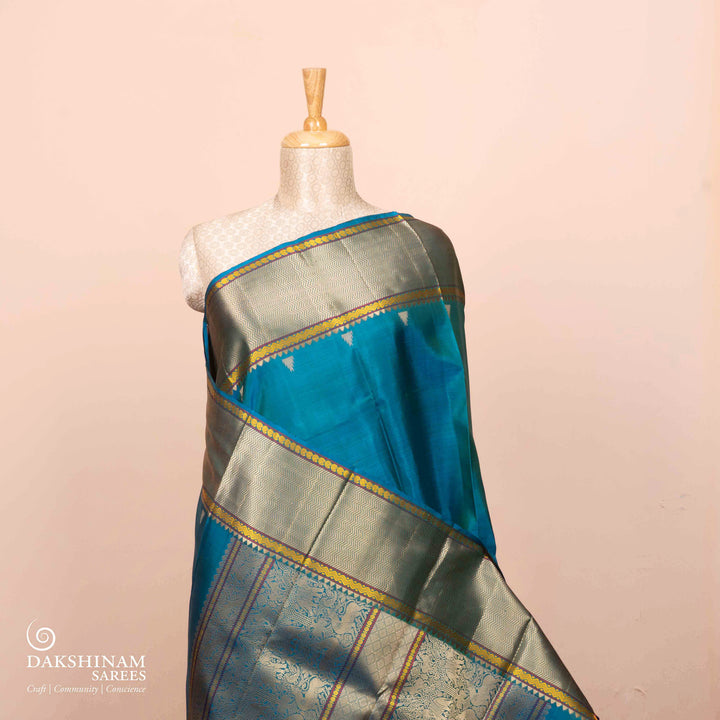Full view of a Blue plain Kanjivaram silk saree with threadwork motifs.