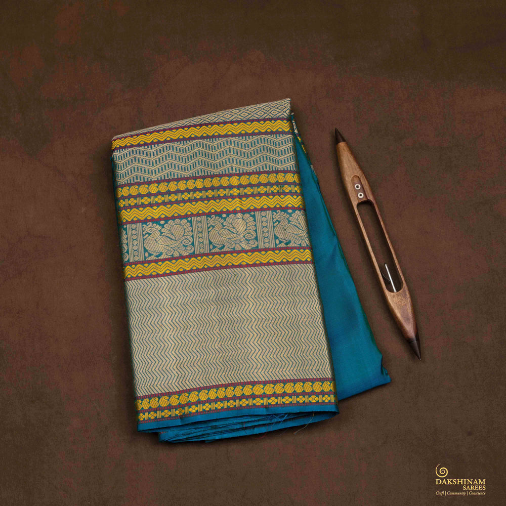 Closeup view of a Blue plain Kanjivaram silk saree with threadwork motifs.