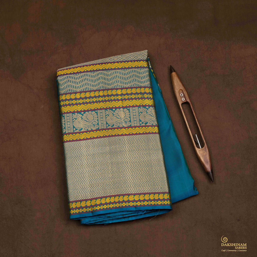 Closeup view of a Blue plain Kanjivaram silk saree with threadwork motifs.