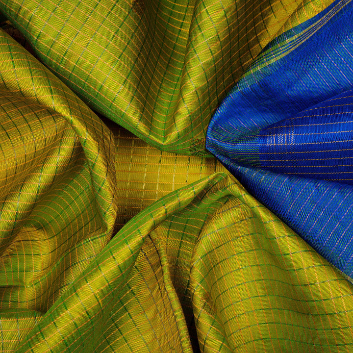 Closeup view of a Light green checked Kanjivaram silk saree with royal blue korvai border.