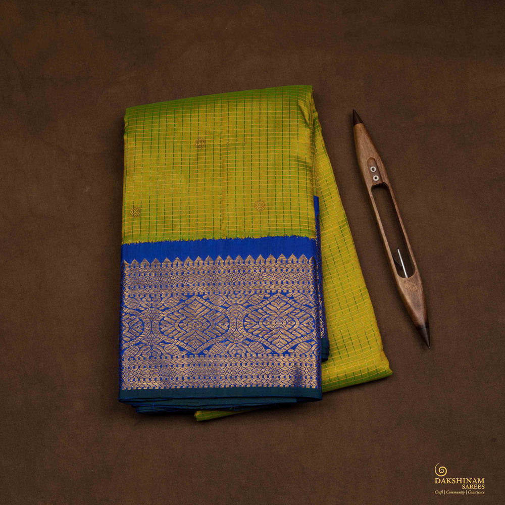 Closeup view of a Light green checked Kanjivaram silk saree with royal blue korvai border.