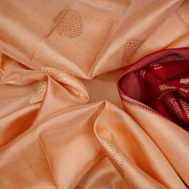 Body Closeup view of a Peach Kanjivaram silk saree with maroon korvai border.