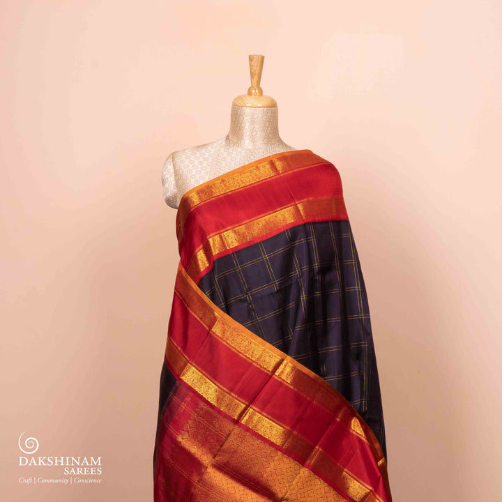 Full view of a Midnight blue Kanjivaram silk saree with red korvai border and gold checks.