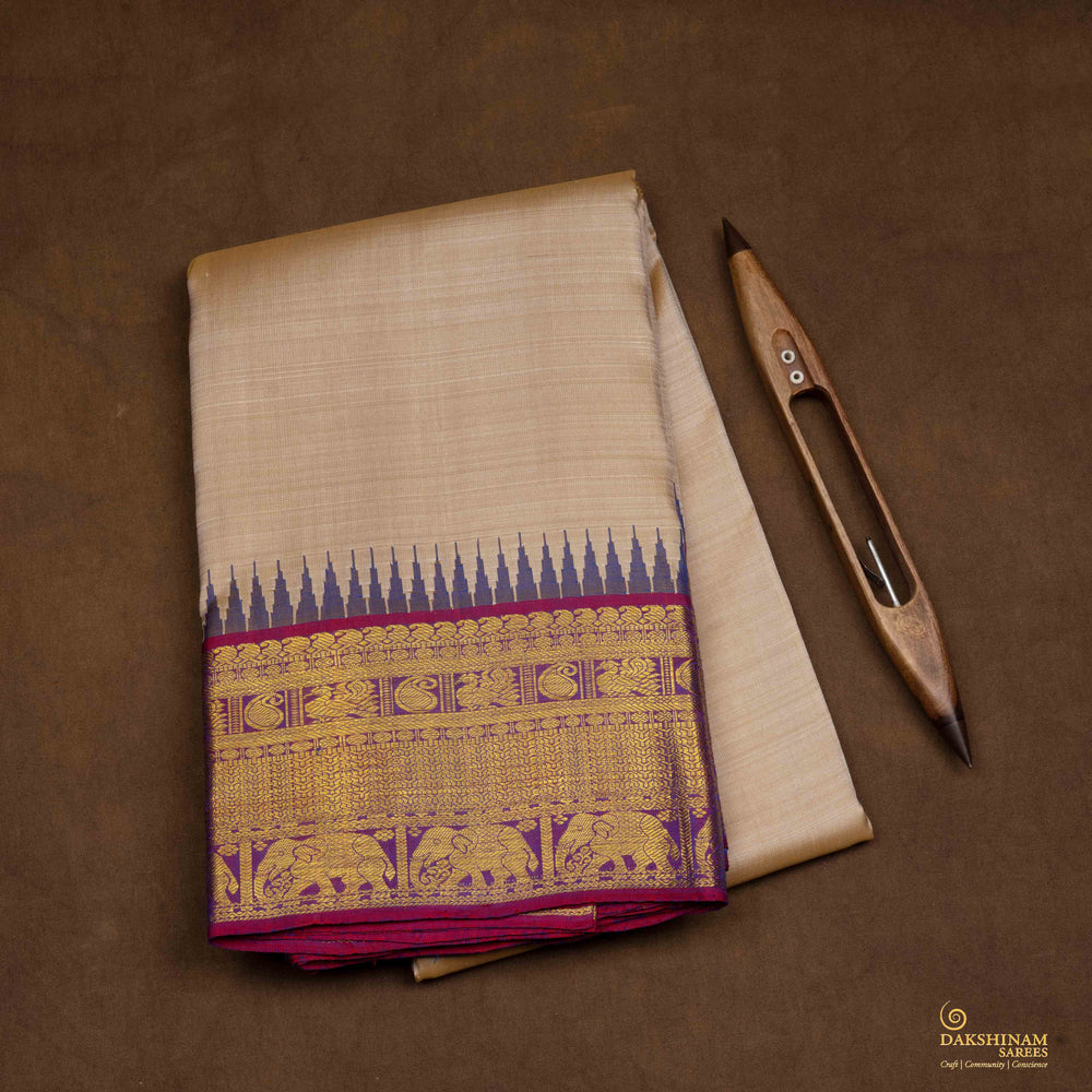 Closeup view of a Beige Kanjivaram silk saree with magenta korvai temple border.