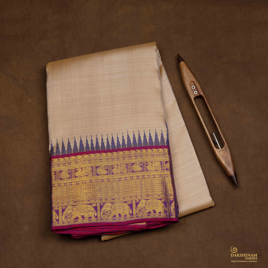 Closeup view of a Beige Kanjivaram silk saree with magenta korvai temple border.