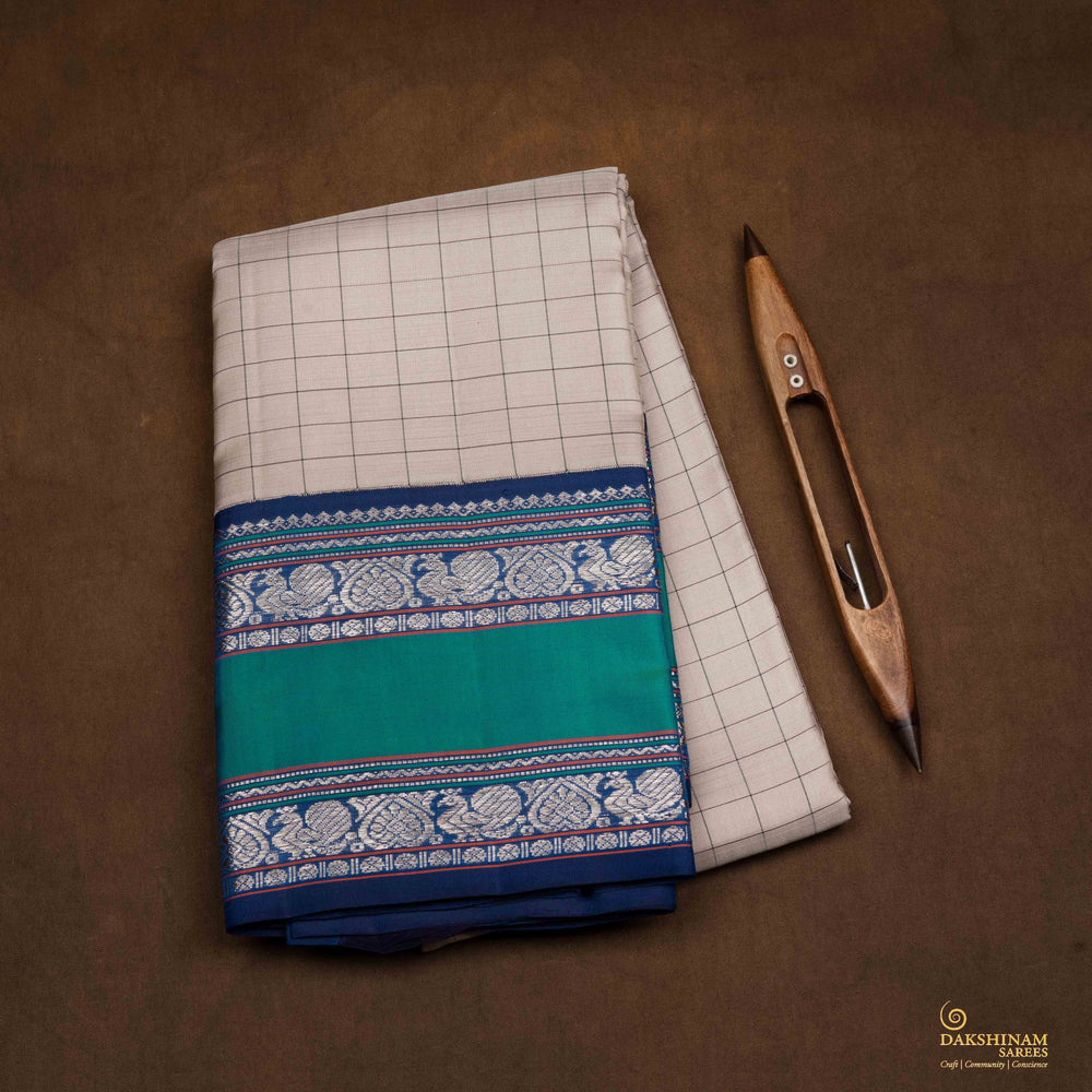 Closeup of a Grey checked Kanjivaram silk saree with blue korvai border.