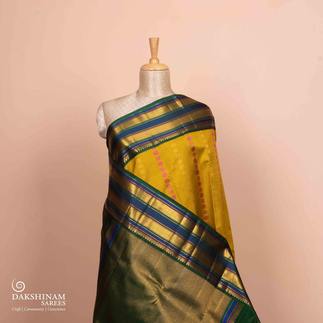 Full view of a Yellow Korvai Kanjivaram silk saree with green border.