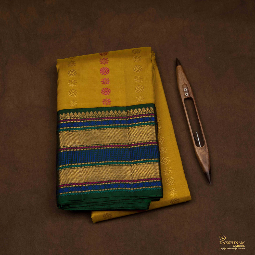 Closeup of a Yellow Korvai Kanjivaram silk saree with green border.