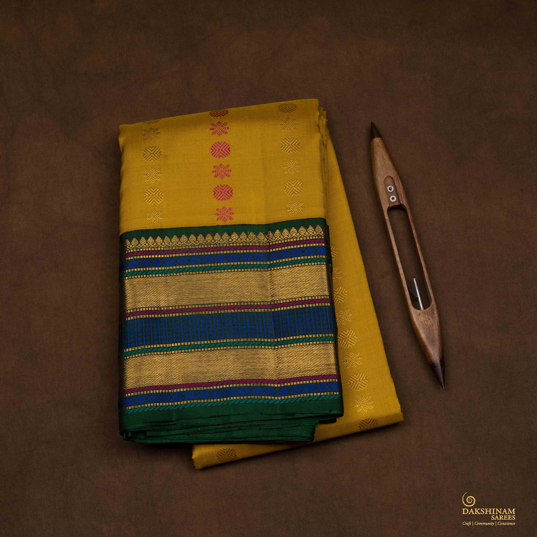 Closeup of a Yellow Korvai Kanjivaram silk saree with green border.