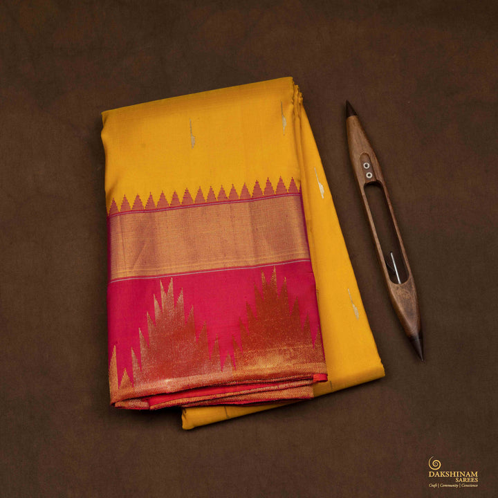 Closeup of a Yellow Korvai Kanjivaram silk saree with red temple border.