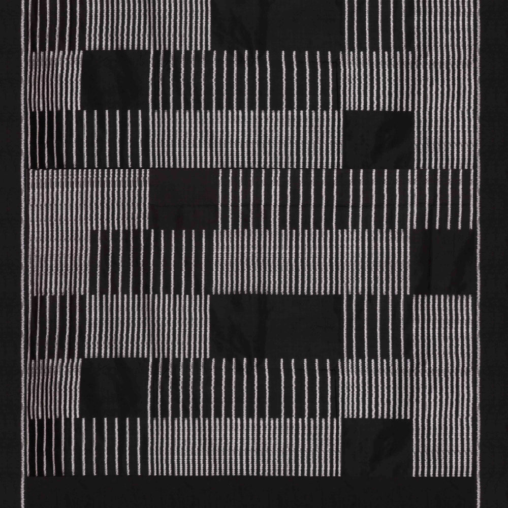 Close-up of a black and white geometric patterned double Ikat saree with striped body.
