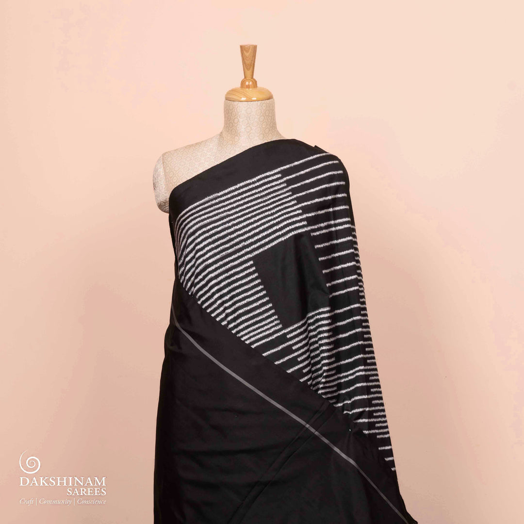 Full view of a Black double Ikat saree with striped body.