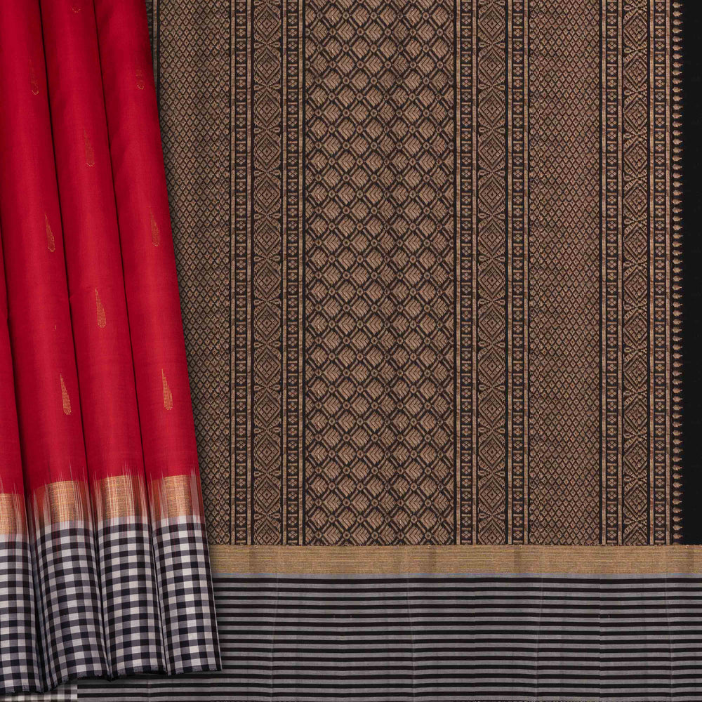 Closeup of a Red soft silk saree with black border and zari buttas.