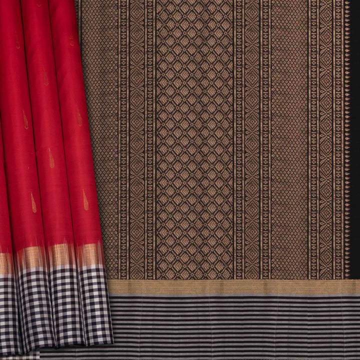 Closeup of a Red soft silk saree with black border and zari buttas.