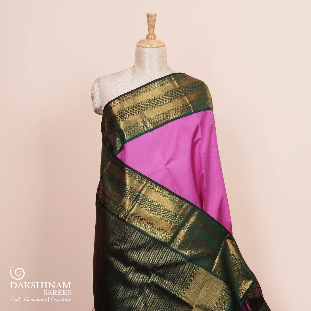 Full view of a Pink korvai Kanjivaram silk saree with green border.