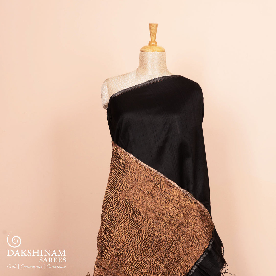 Full view of a Black Dupion silk saree with copper tissue pallu.