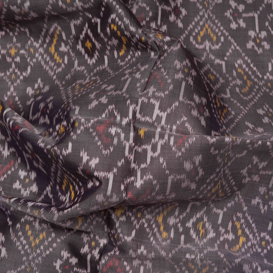 Closeup of Handwoven grey and red Ikat silk Saree