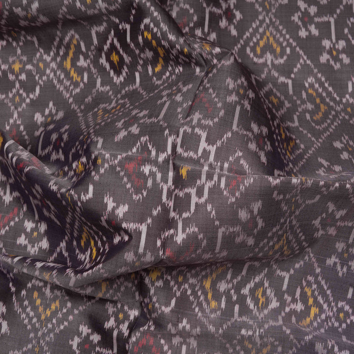 Closeup of Handwoven grey and red Ikat silk Saree