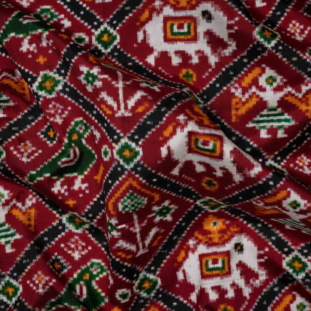 Close-up of a fabric with elephant and diamond pattern on a red background