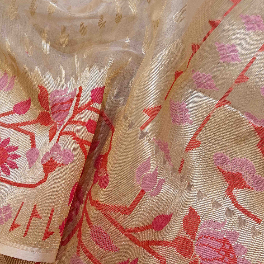 Close-up of floral embroidered fabric with red and pink patterns on beige background