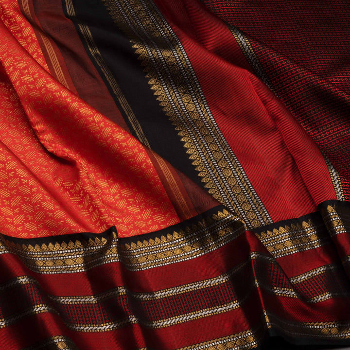 Close-up of a red and black saree with gold patterns