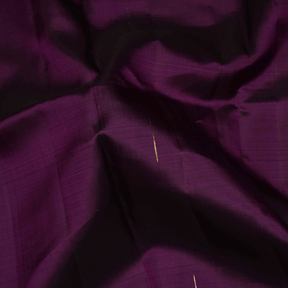 Close-up of purple fabric with a needle threaded through it.