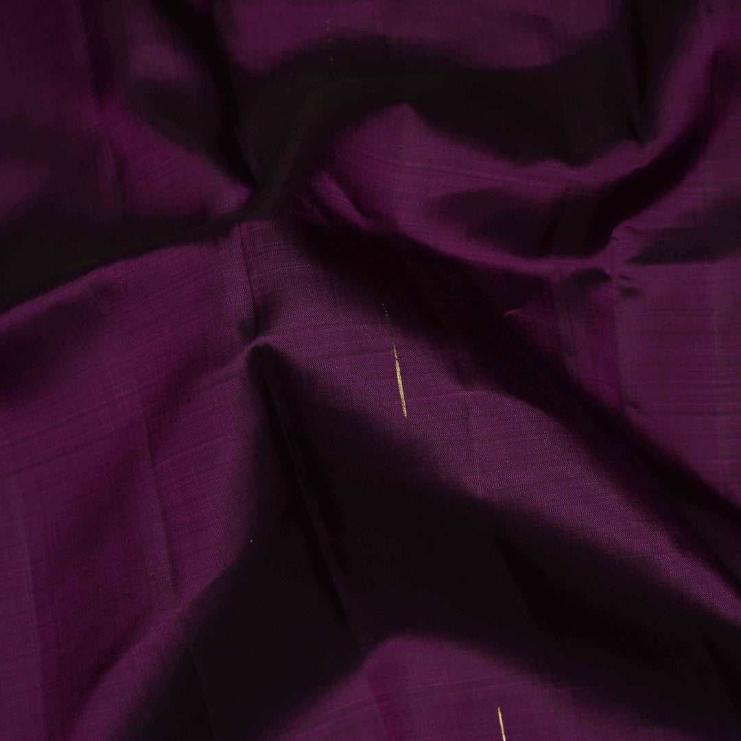 Close-up of purple fabric with a needle threaded through it.