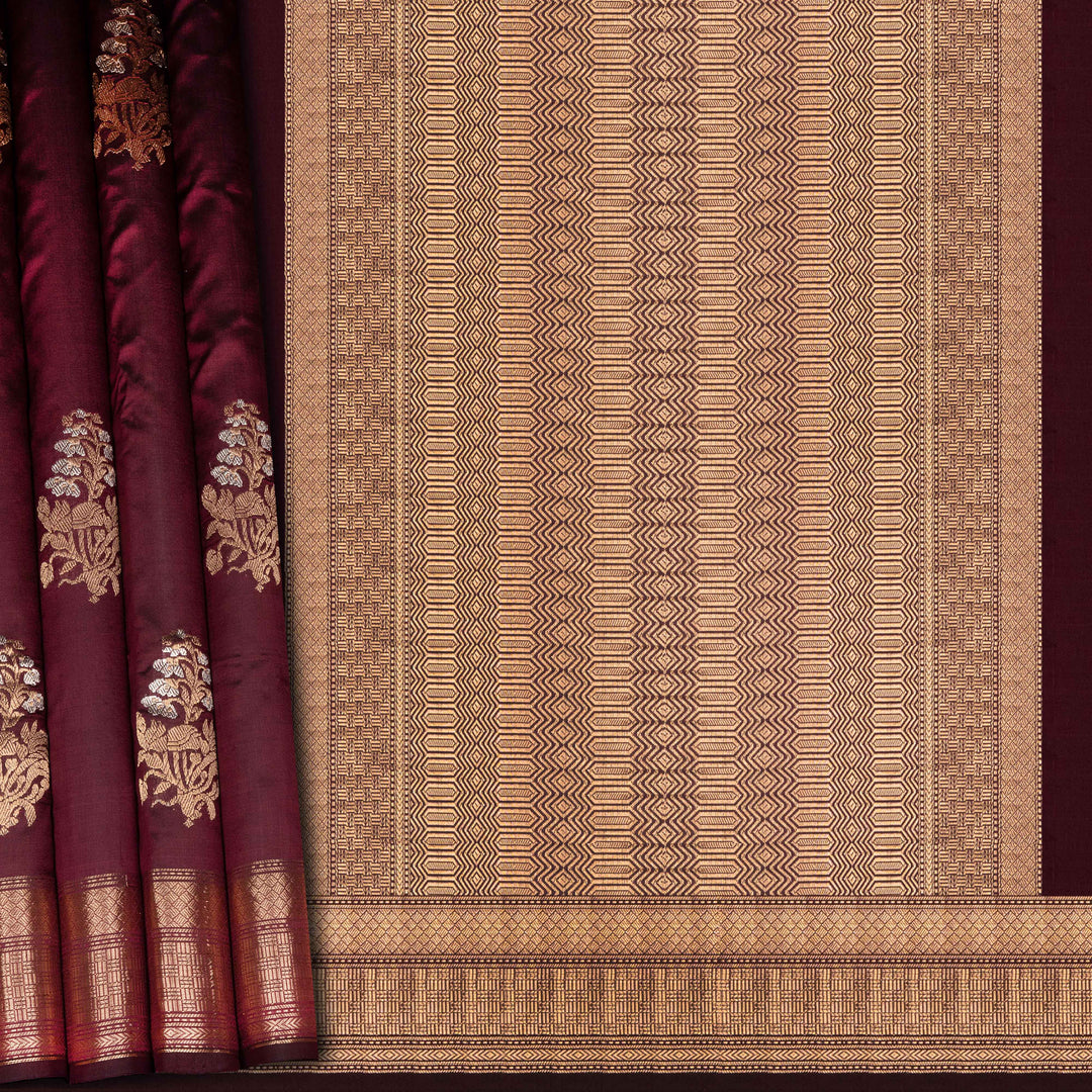 Maroon fabric with gold embroidery and a geometric patterned border