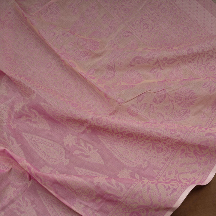 Pink South cotton saree with plant and paisley motifs across the body, floral border and peacock motif pallu, matching blouse with diamond butta design.
