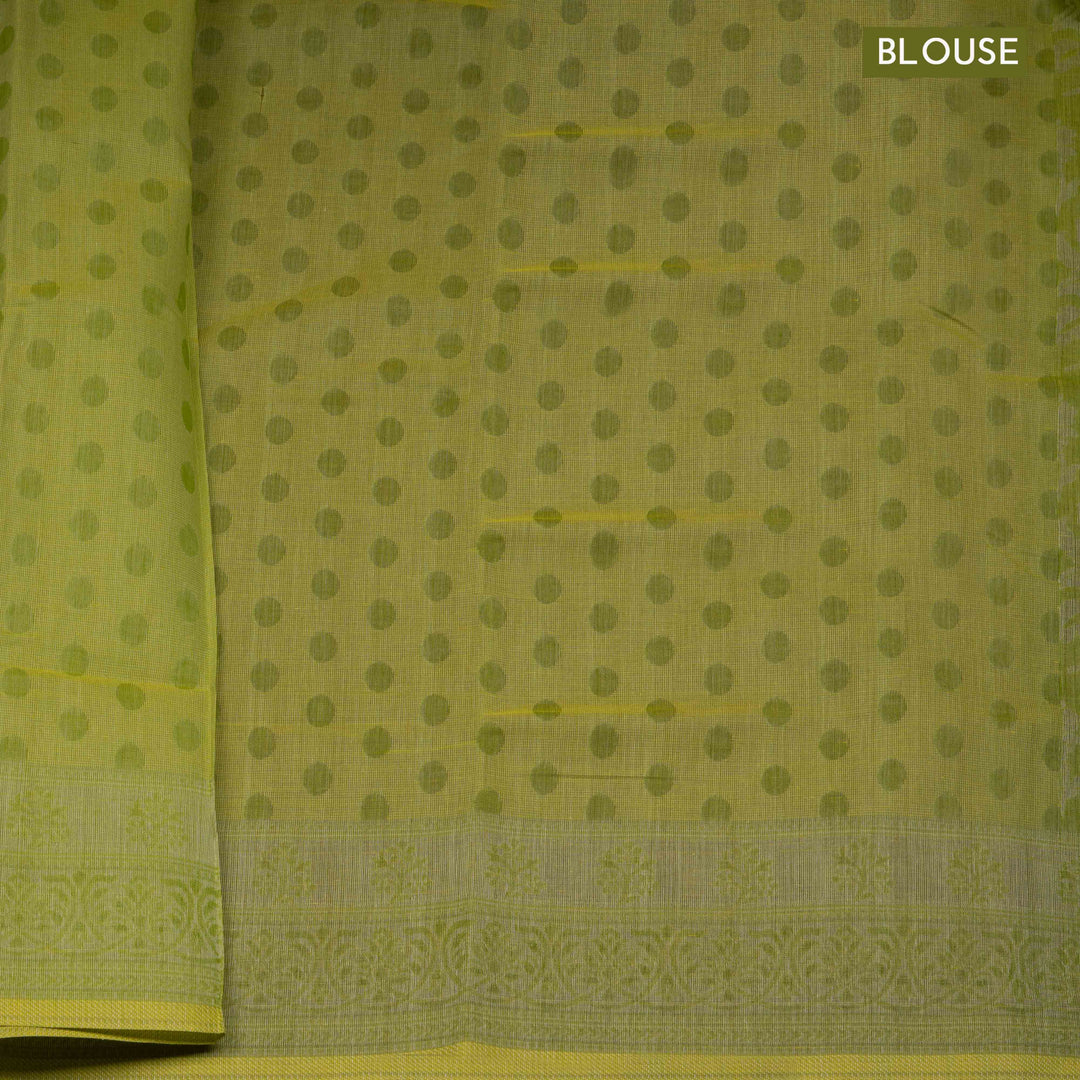 Lime green South cotton saree with floral body featuring peacock, horse, elephant, deer and tiger motifs, traditional border and paisley pallu, matching blouse with dot design.