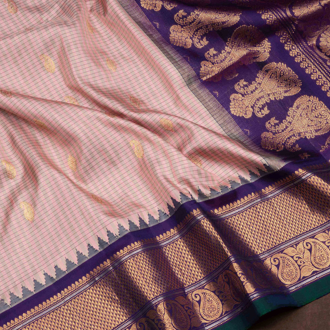 Peach Gadwal silk saree with grey checks and small butta body, purple zari border with mango and leaf motifs, plain purple blouse.